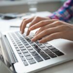 Close up of hands typing on laptop