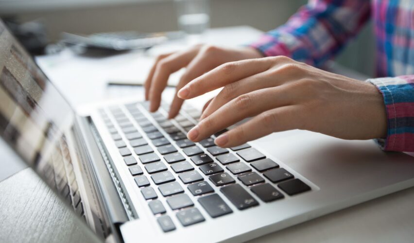 Close up of hands typing on laptop