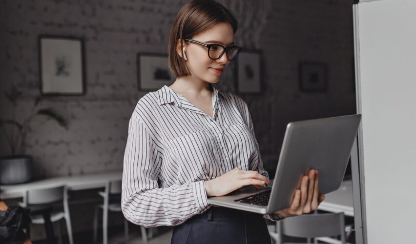 The girl is holding a laptop in her hands