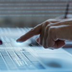 programming background with a person pressing the keyboard on the laptop