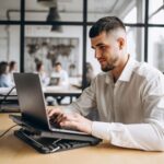 A man works on his laptop in the office